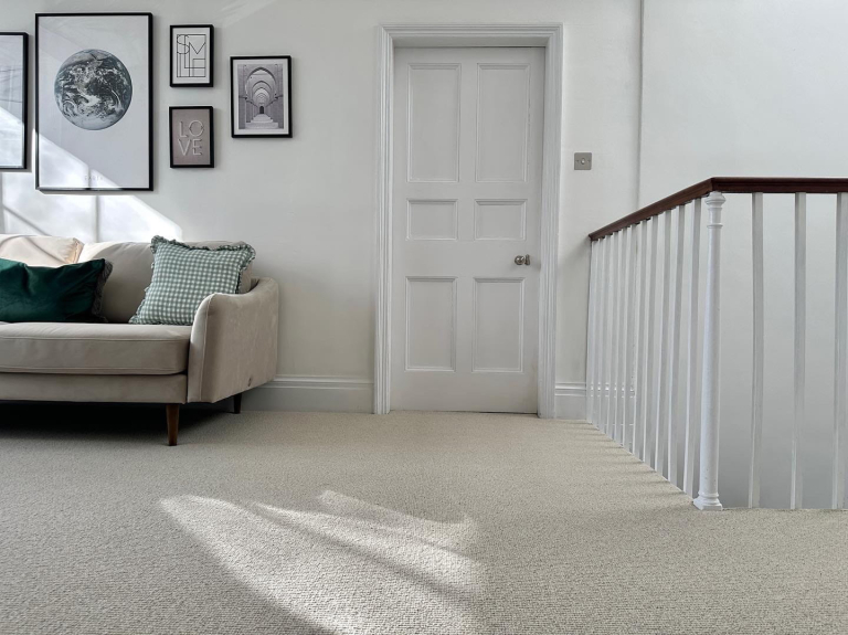 Softer Than Sisal carpet on a bright staircase with white railing